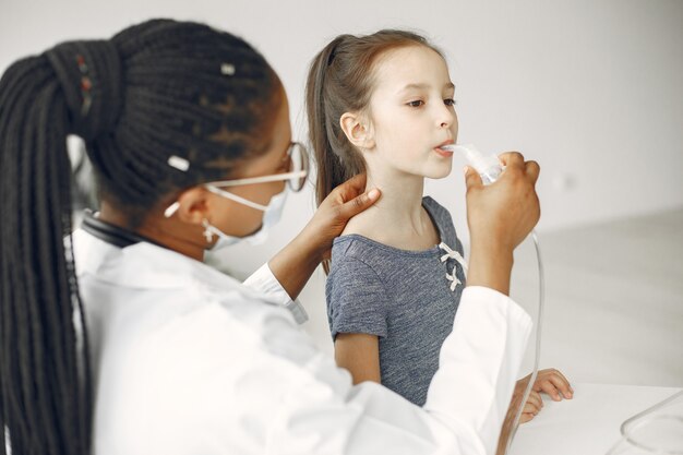 Arts in een beschermend masker. kind inhaleert. afrikaanse vrouw.