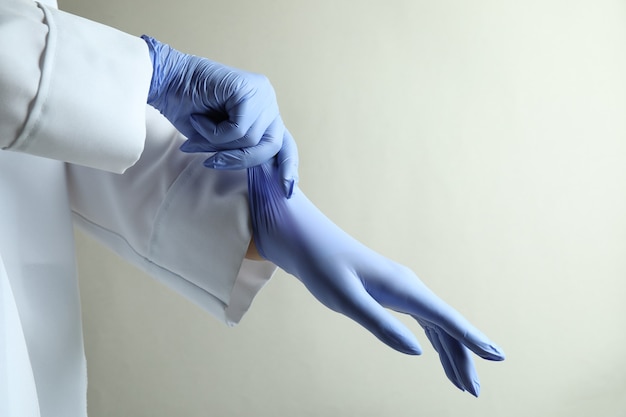 Foto arts medische handschoenen zetten lichtgrijze geïsoleerde achtergrond