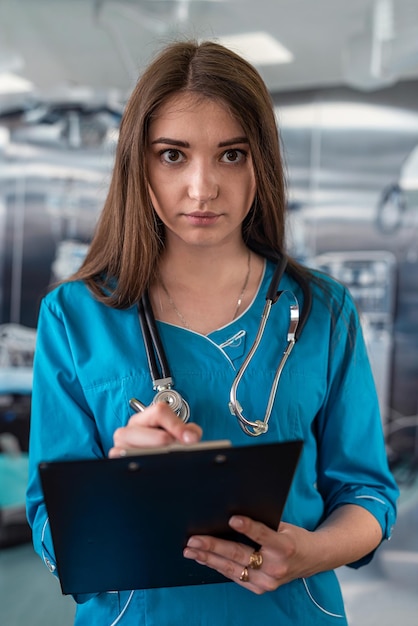 Arts met stethoscoop in operatiekamer met klembord met operatiekamer op de achtergrond