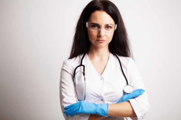 Arts met veiligheidsbril en stethoscoop op haar werkruimte