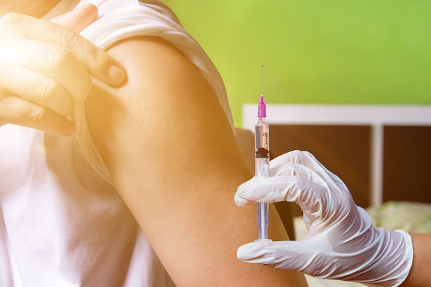 Arts of verpleegkundige injecteert COVID-19-vaccin bij de patiënt, vaccinatie en preventie tegen griep en Corona-virus of covid-19-pandemie