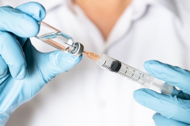 Arts of verpleegster hand met griepvaccin injectie voor baby vaccinatie