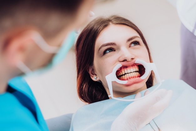 Arts-orthodontist voert een procedure uit voor het reinigen van tanden