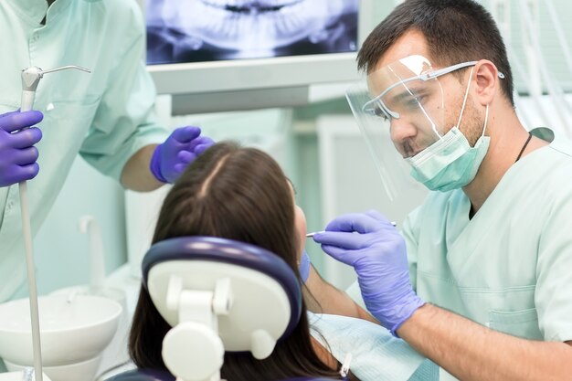 Arts Tandarts met een assistent werk in een tandheelkundige kliniek.