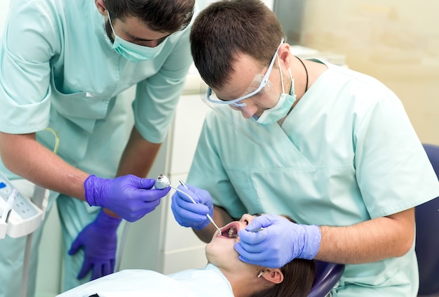 Arts Tandarts met een assistent werk in een tandheelkundige kliniek.