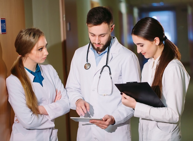 Artsen bespreken het cardiogram van de patiënt op de tablet.