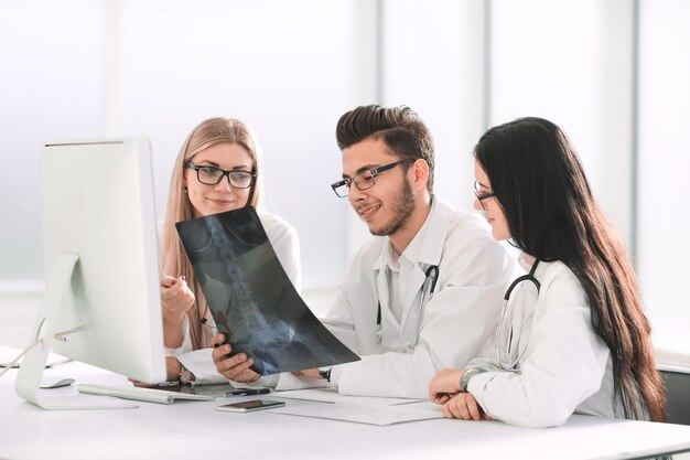 Artsen-experts bespreken röntgenfoto's, zittend aan tafel