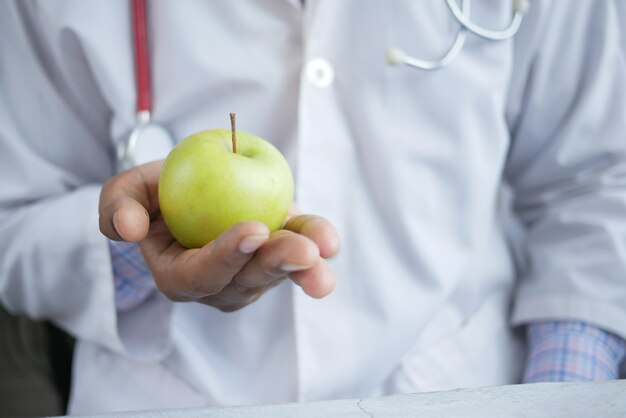 Artsen houden groene appel vast terwijl ze zitten