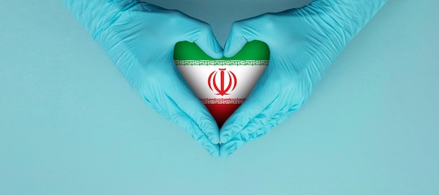 Artsenhanden die blauwe chirurgische handschoenen dragen en een vormsymbool horen met de vlag van Iran