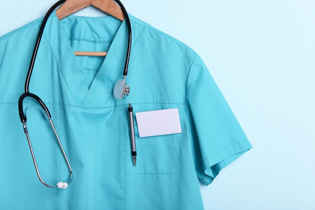 Artsenhemd met stethoscoop op hanger op blauwe achtergrond