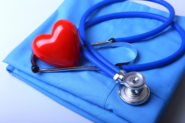 Artsenlaag met medische stethoscoop en rood hart op het bureau