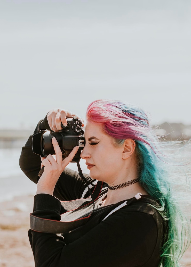 Photo artsy woman taking a photo at a beach