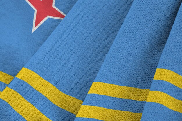 Aruba flag with big folds waving close up under the studio light indoors The official symbols and colors in banner