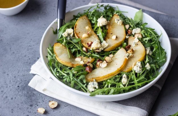 Photo arugula, gorgonzola cheese, caramelized pear and nut salad