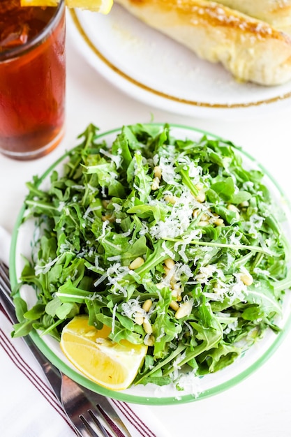 Arugula salad with pine nuts on the plate in Italian restaurant.