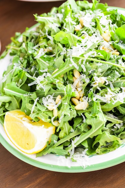 Arugula salad with pine nuts on the plate in Italian restaurant.