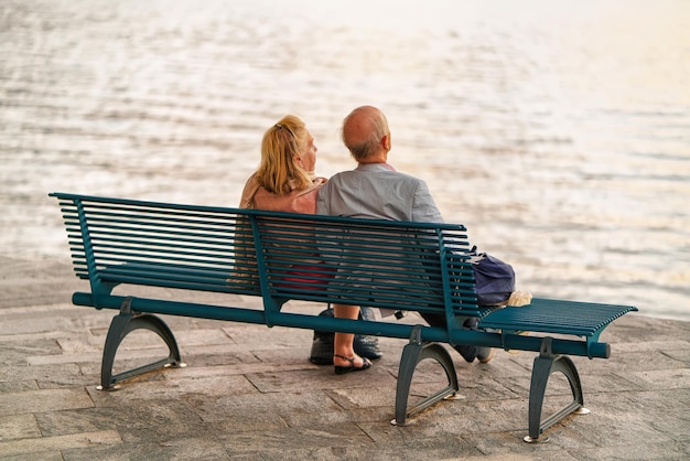 Ascona, Switzerland - August 23, 2016: Senior Couple sitting on the bench at the embankment of Ascona on Lake Maggiore, Ticino canton of Swiss