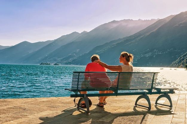 Ascona, Zwitserland - 23 augustus 2016: Romantisch paar zittend op het bankje aan de promenade van het luxe resort in Ascona aan het Lago Maggiore, kanton Ticino in Zwitserland.