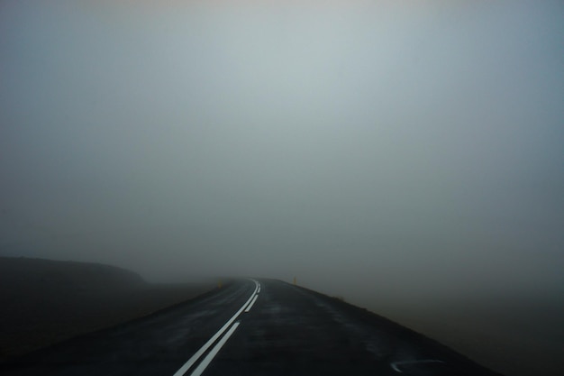 Asfalt natte weg en dikke mist. Ruimte voor tekst landschap landschap
