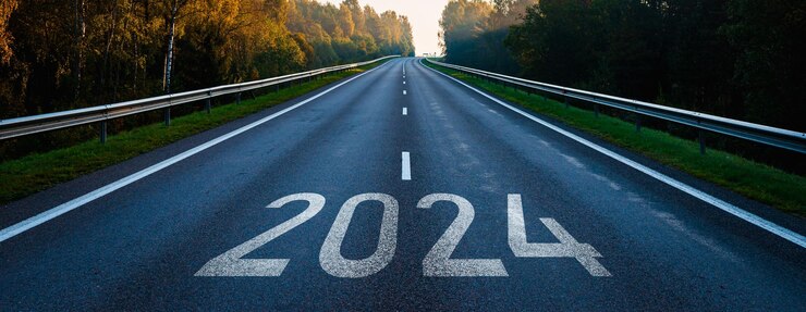 Foto asfaltweg met 2024 tekst gaat naar de horizon zonneschijn aan de horizon en de weg recht vooruit vooruit naar het nieuwe jaar concept duidelijke en positieve perspectieven vooruit vroege herfst ochtendbanner