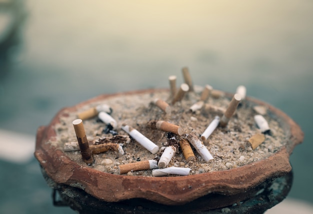 Ashtray full of cigarette butts. Used cigarette in ashtray.