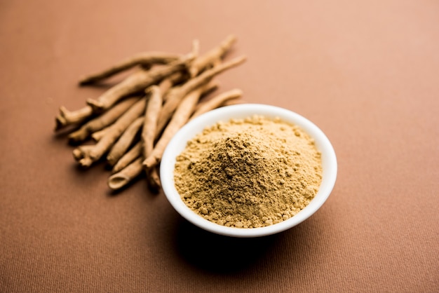 Ashwagandha or Aswaganda OR Indian Ginseng is an Ayurveda medicine in stem and powder form. Isolated on plain background. selective focus