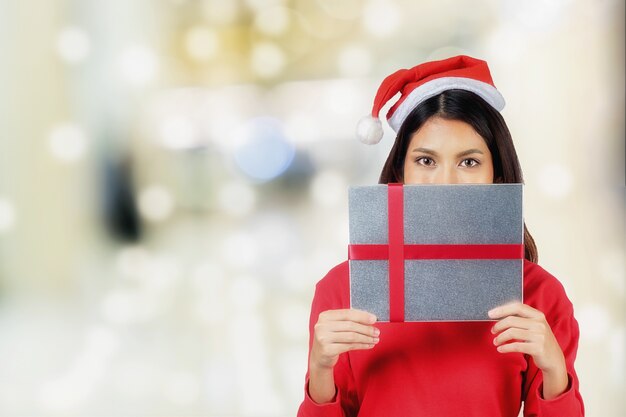 Asia Beautiful girl in santa uniform open gift box with over shopping center background.