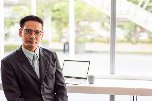 Asia business man working with laptop while sitting coffee shop .Concept of young  business people 