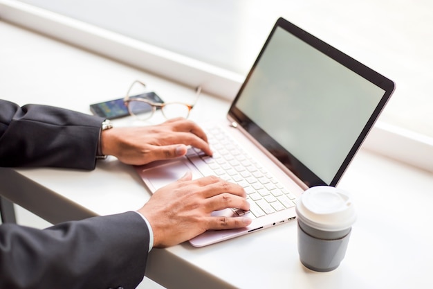 Asia business man working with laptop while sitting coffee shop 