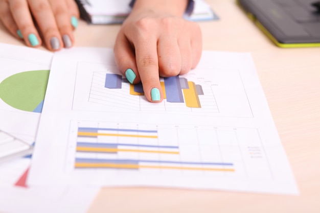 Asia business woman analyzing investment charts on desk