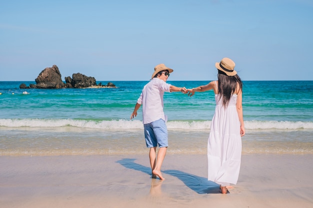 Asia couple traveler happy on the beach during holiday.