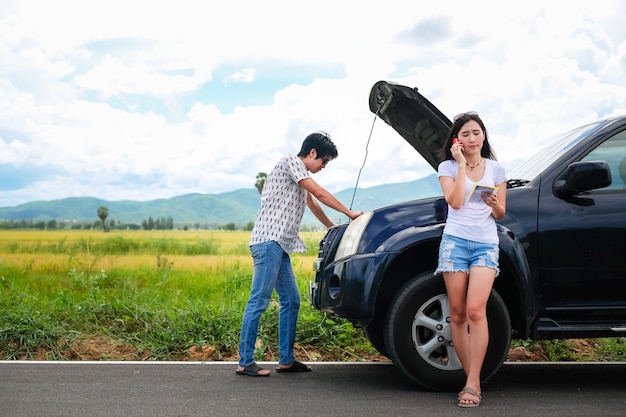 Photo asia couple traveler have a problem about car.