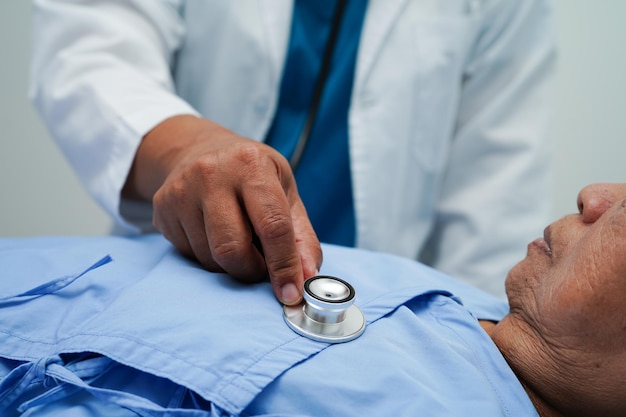 Asia doctor with stethoscope checking elderly woman patient in hospital healthy medical concept