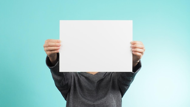 Photo asia female hands is holding blank a4 paper with grey t shirt on green or tiffany blue background