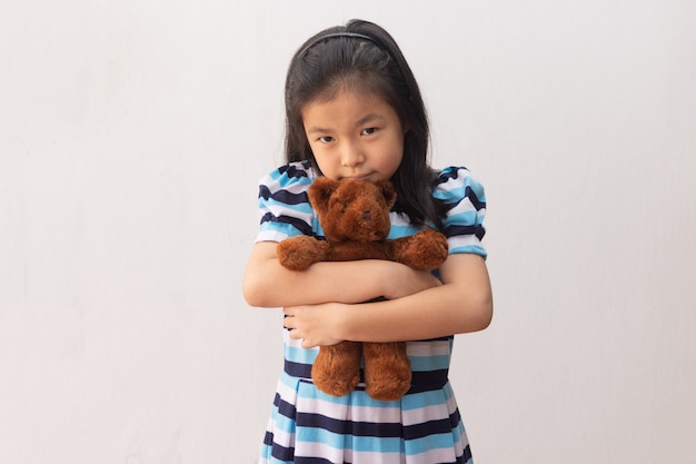 Asia girl hugging a teddy bear