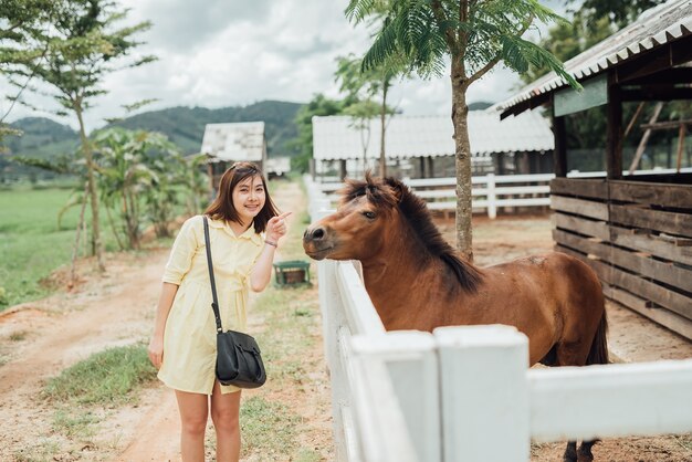 Asia girl playing with pony at zoo