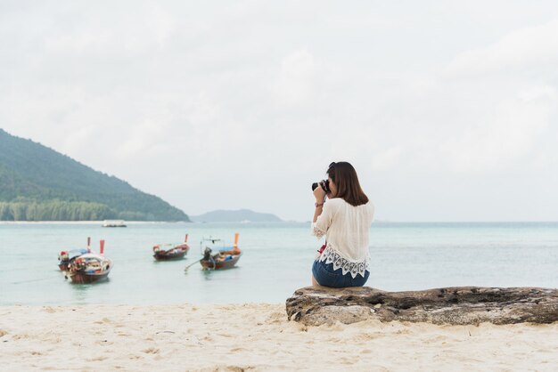 Asia girl sitting and take photo on the beach