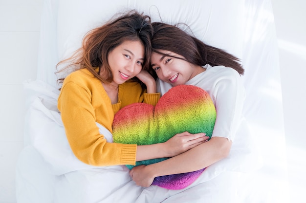 Premium Photo Asia Lesbian Lgbt Couple Lay On Bed And Hug Rainbow Color Pillow Heart Shape