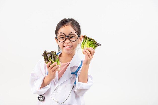 Маленькая азиатская девочка, играющая в доктора, рекомендует овощи и фрукты для правильного