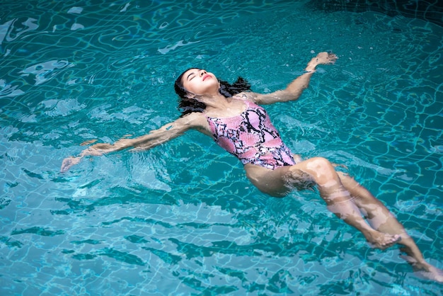 Asia sexy woman in the bikini pool Swimming pool tanned slim and shapely body Girl enjoying travel holidays at resort luxury overwater bungalow