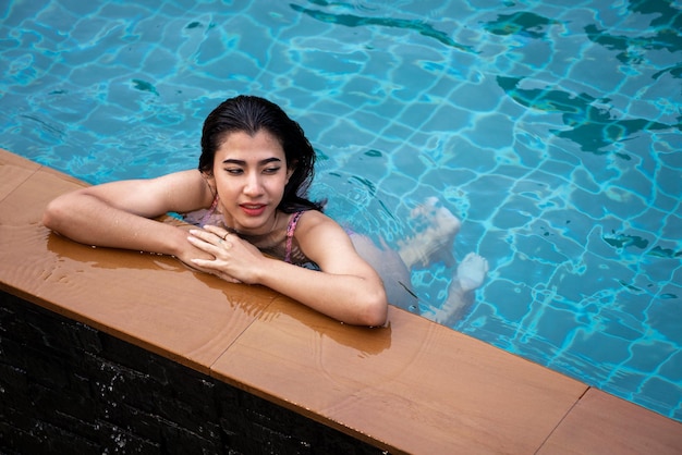 비키니 수영장에서 아시아 섹시한 여자 수영장 그을린 슬림하고 매끈한 몸 리조트 럭셔리 수상 방갈로에서 여행 휴가를 즐기는 소녀