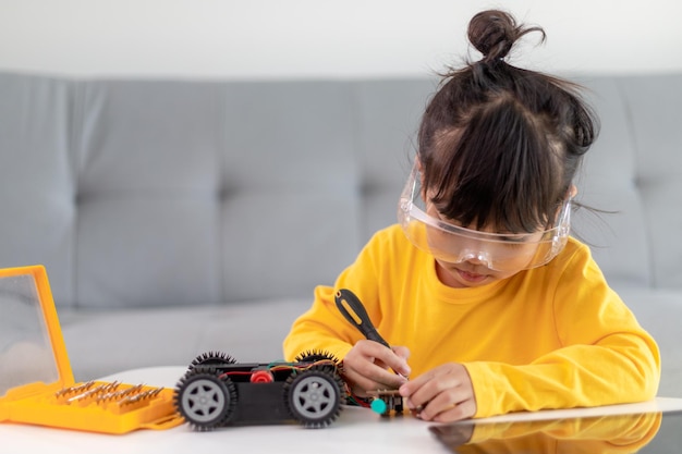 Asia students learn at home in coding robot cars and electronic board cables in STEM, STEAM, mathematics engineering science technology computer code in robotics for kids concept.