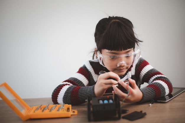 Студенты из Азии учатся дома в кодировании машин-роботов и кабелей электронных плат в STEM, STEAM, математике, инженерных науках, технологиях, компьютерных кодах в концепции робототехники для детей.