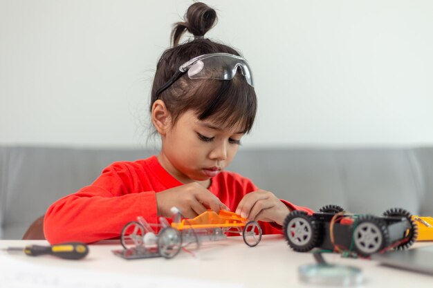 Asia students learn at home in coding robot cars and electronic board cables in STEM STEAM mathematics engineering science technology computer code in robotics for kids concept