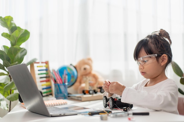 아시아 학생들은 STEM STEAM 수학 공학 과학 기술 컴퓨터 코드 로봇 공학에서 로봇 자동차와 전자 보드 케이블을 코딩하는 방법을 집에서 배웁니다.