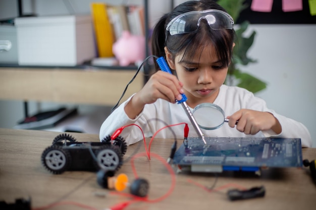 Gli studenti asiatici imparano a casa a codificare auto robot e cavi di schede elettroniche in stem steam