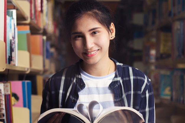 Photo asia teen, girl, student reading book with happy in the library.