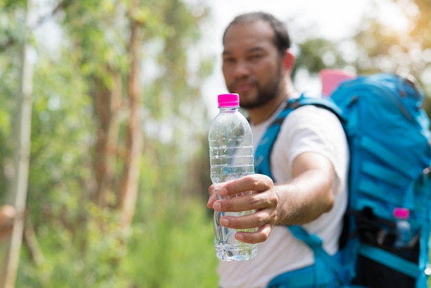 Asia traveler holding a water bottle in outdoor forest 