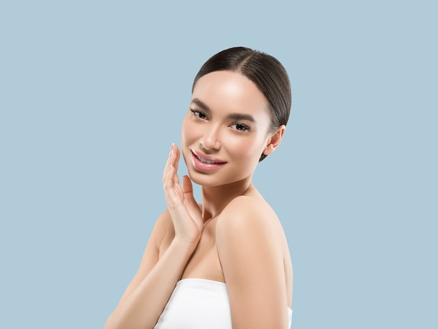 Asia woman beauty face body portrait touching her face healthy skin. Color background. Blue