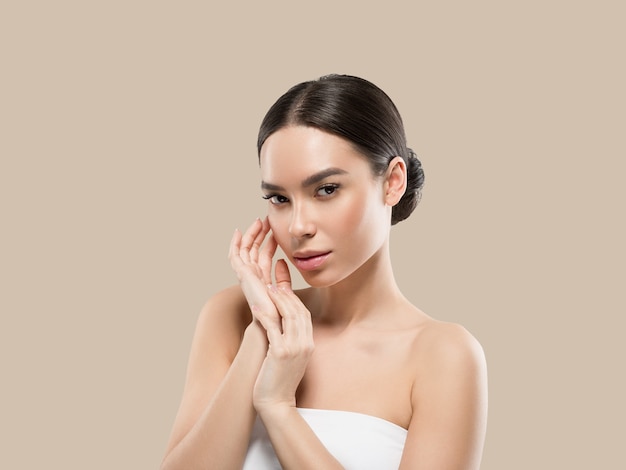 Asia woman beauty face body portrait touching her face healthy skin. Color background. Brown